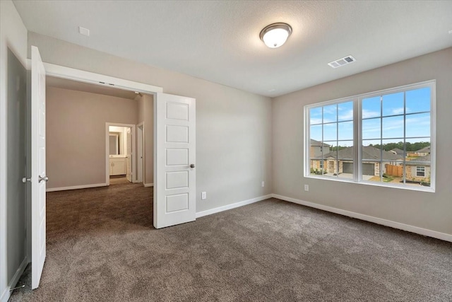 unfurnished bedroom with dark carpet