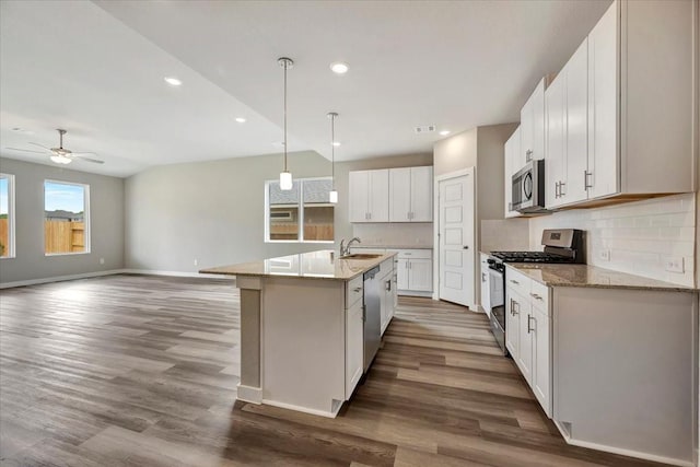 kitchen with sink, white cabinetry, appliances with stainless steel finishes, an island with sink, and decorative backsplash