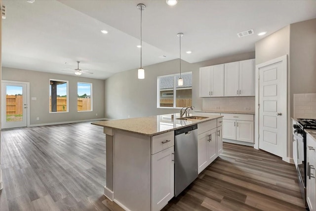 kitchen with appliances with stainless steel finishes, white cabinetry, an island with sink, sink, and decorative backsplash