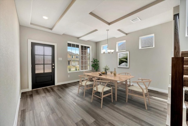 dining space with coffered ceiling, an inviting chandelier, and dark hardwood / wood-style flooring