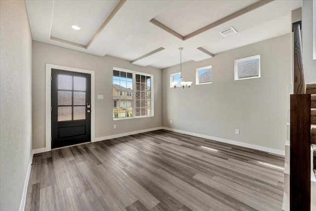 entrance foyer featuring hardwood / wood-style flooring, coffered ceiling, and an inviting chandelier