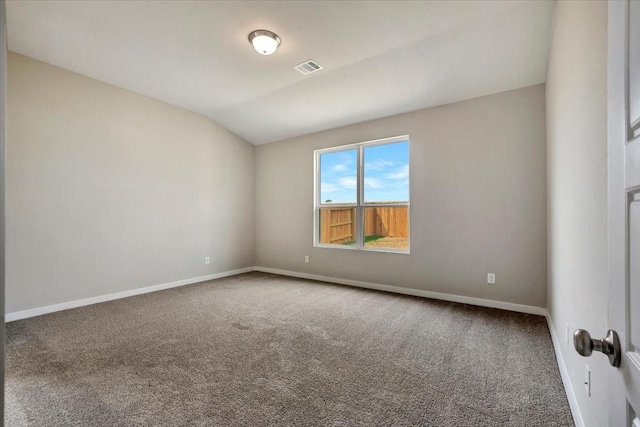 carpeted spare room with vaulted ceiling