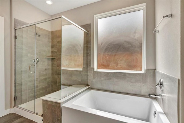 bathroom with wood-type flooring and separate shower and tub