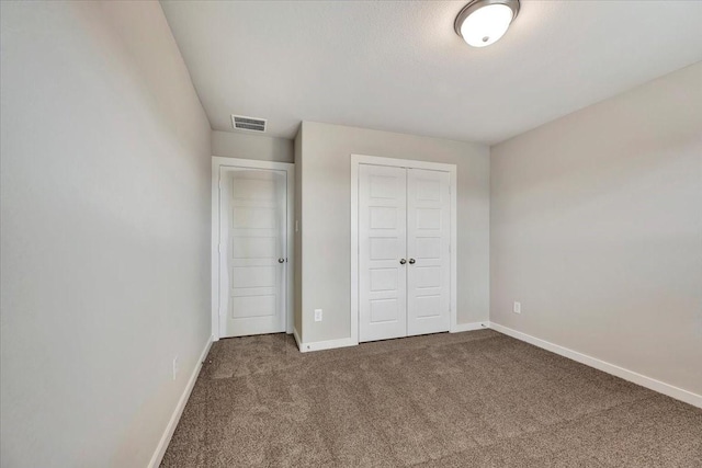 unfurnished bedroom with a closet and carpet