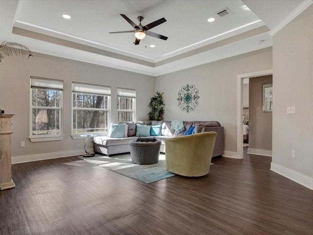 living room featuring crown molding, dark hardwood / wood-style floors, and a tray ceiling