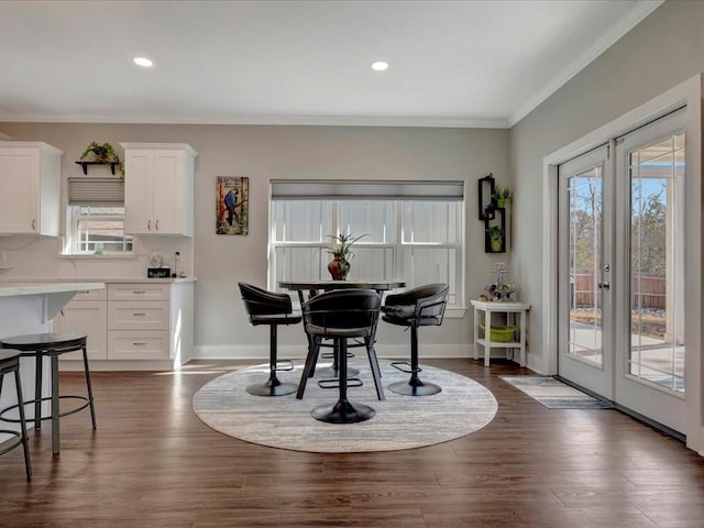 dining space featuring dark wood-type flooring, ornamental molding, and french doors