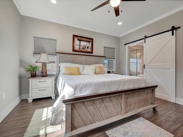 bedroom featuring dark hardwood / wood-style flooring, a barn door, ornamental molding, and ceiling fan