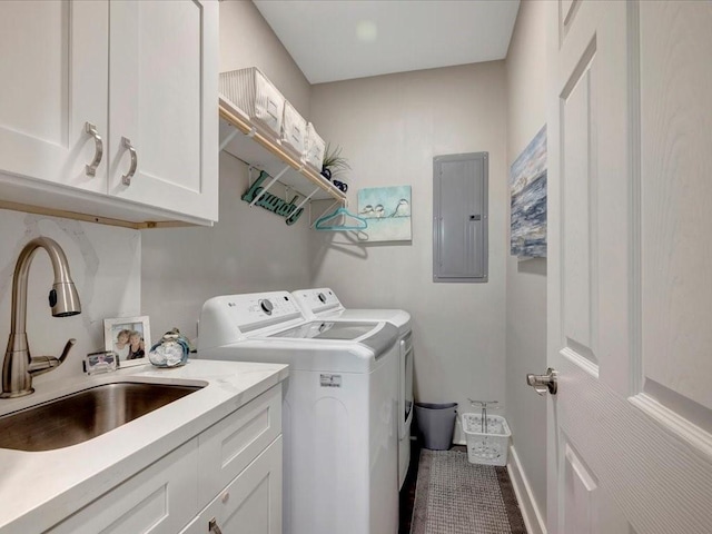 washroom featuring cabinets, washing machine and clothes dryer, electric panel, and sink