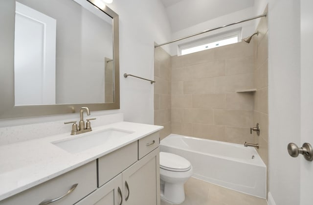 full bathroom featuring tiled shower / bath, vanity, toilet, and tile patterned flooring