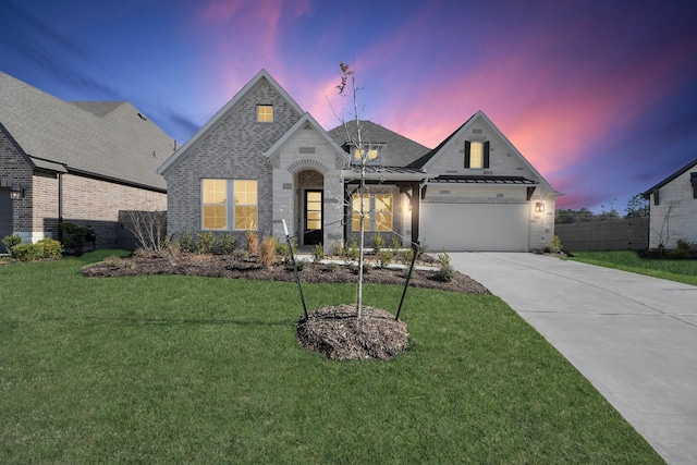 french country inspired facade with brick siding, a yard, fence, a garage, and driveway