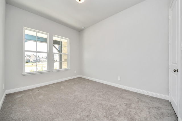 empty room featuring carpet flooring and baseboards