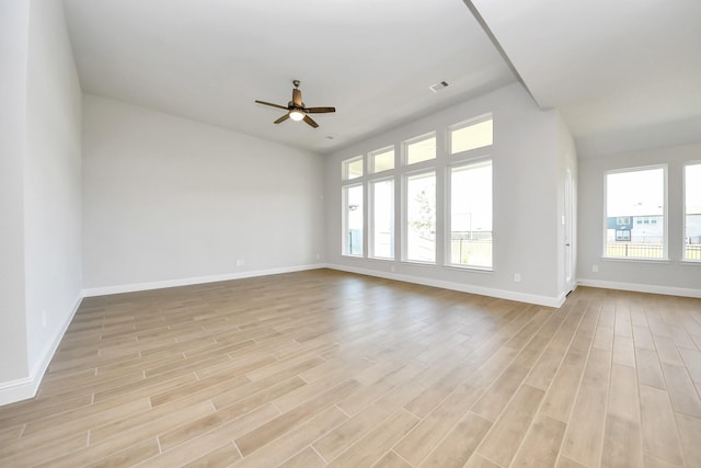 unfurnished room featuring visible vents, light wood finished floors, a ceiling fan, and baseboards