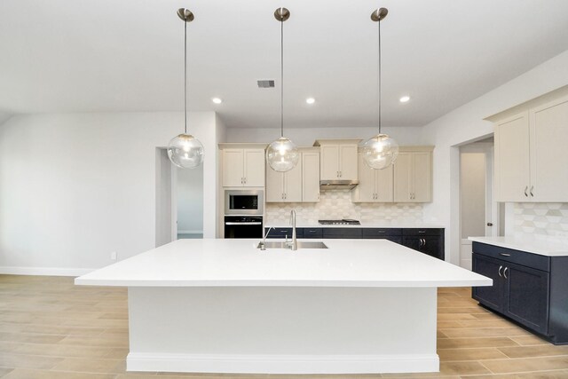 kitchen with light countertops, visible vents, decorative backsplash, appliances with stainless steel finishes, and a sink