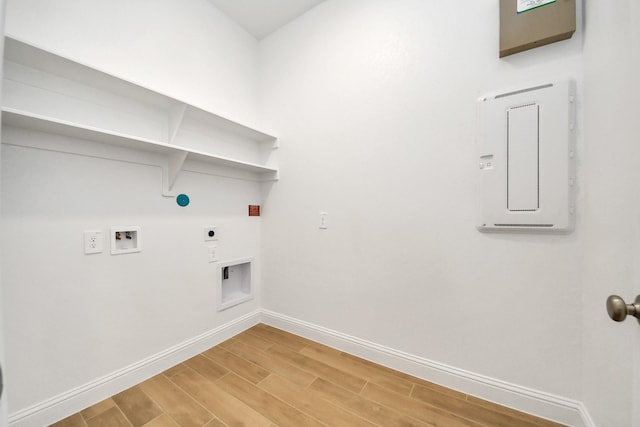 clothes washing area with wood finish floors, hookup for a washing machine, hookup for an electric dryer, laundry area, and baseboards