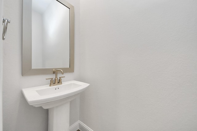 bathroom featuring a sink and baseboards