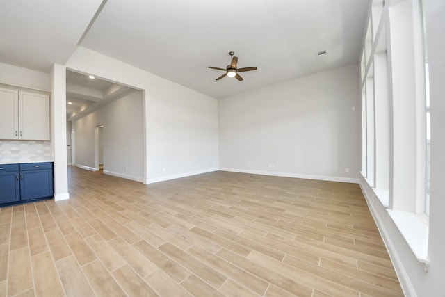 unfurnished living room with light wood-style flooring, baseboards, a ceiling fan, and recessed lighting