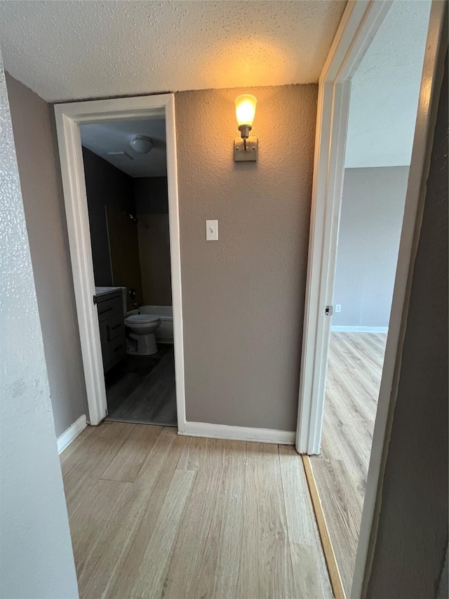 hallway featuring hardwood / wood-style floors and a textured ceiling