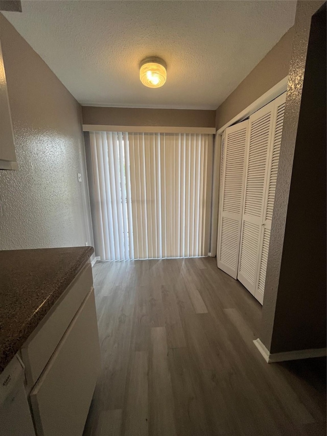 hallway featuring hardwood / wood-style floors and a textured ceiling