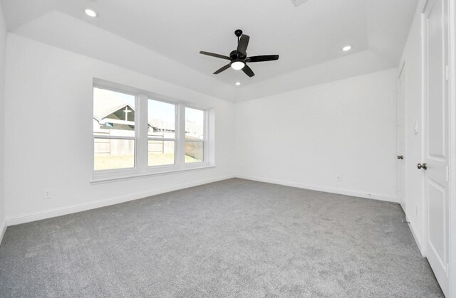 carpeted spare room featuring baseboards, a tray ceiling, and recessed lighting