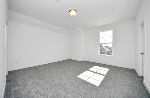 spare room featuring dark colored carpet