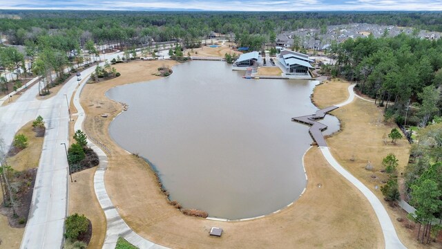 birds eye view of property featuring a water view and a wooded view