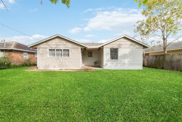 back of house featuring a lawn