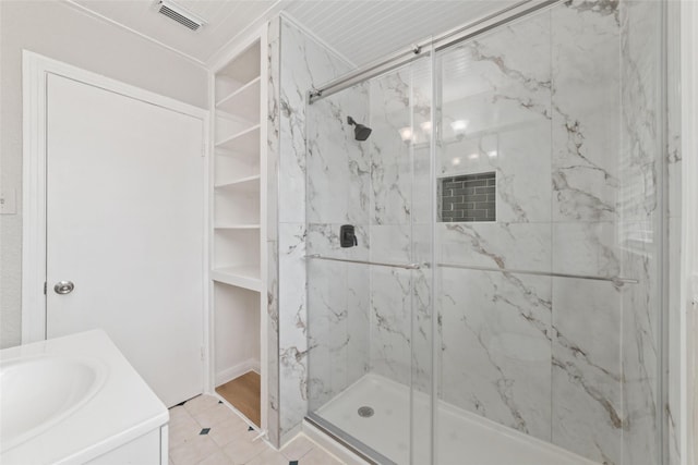 bathroom with tile patterned flooring, vanity, and walk in shower