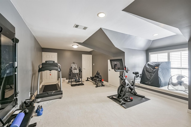 exercise area featuring carpet, visible vents, vaulted ceiling, and baseboards