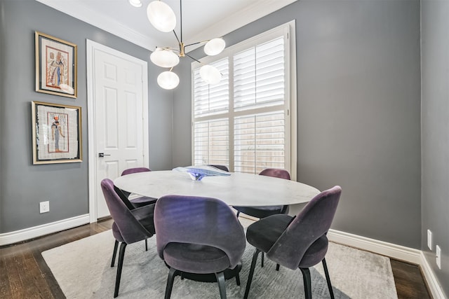 dining area with ornamental molding, an inviting chandelier, baseboards, and wood finished floors