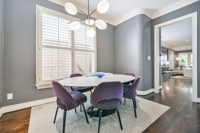 dining area featuring dark wood-style floors, baseboards, and crown molding