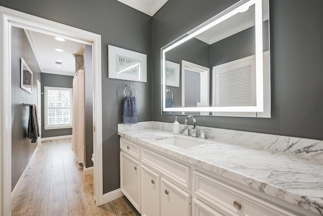 full bath with baseboards, toilet, wood finished floors, crown molding, and vanity