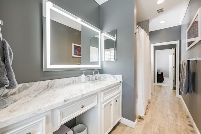 full bathroom featuring baseboards, visible vents, wood finished floors, vanity, and recessed lighting