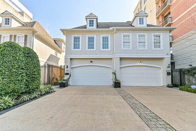 view of front of house with driveway, an attached garage, fence, and stucco siding