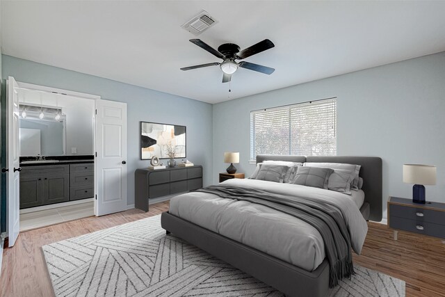 bedroom with sink, connected bathroom, ceiling fan, and light hardwood / wood-style flooring