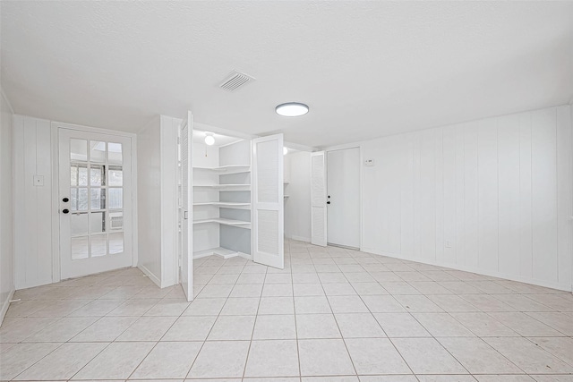 interior space featuring a textured ceiling and light tile patterned floors