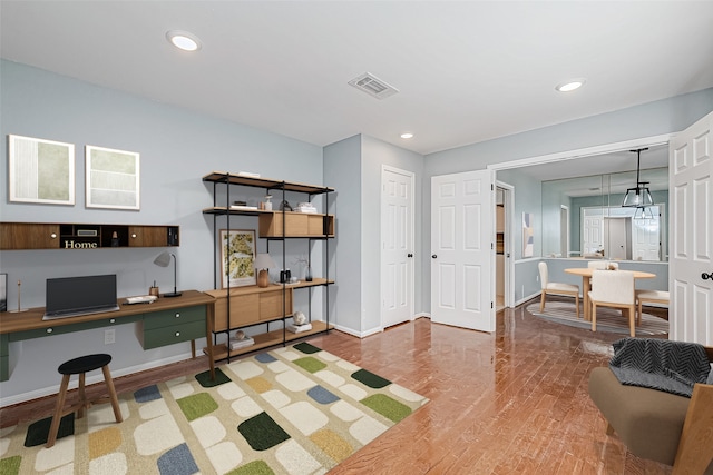 office space with built in desk and hardwood / wood-style floors