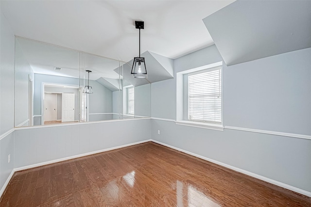 unfurnished dining area with lofted ceiling and wood-type flooring