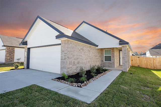 ranch-style home with a garage and a lawn