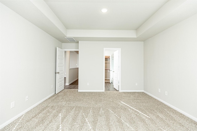 unfurnished bedroom featuring a walk in closet, carpet flooring, and a closet