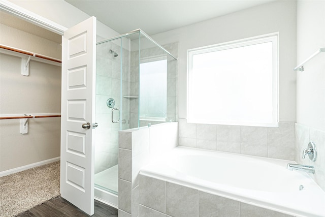 bathroom with wood-type flooring and separate shower and tub