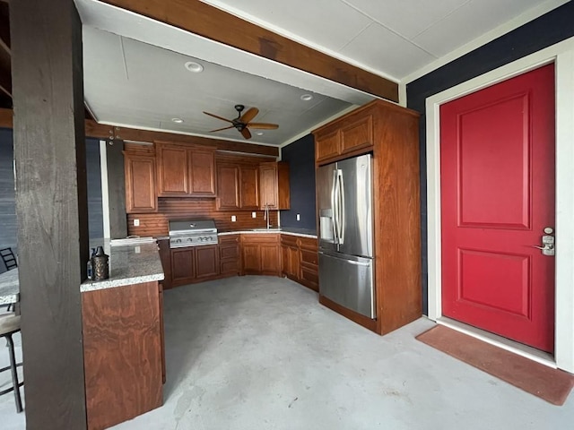 kitchen with stainless steel fridge with ice dispenser, light stone countertops, sink, and ceiling fan