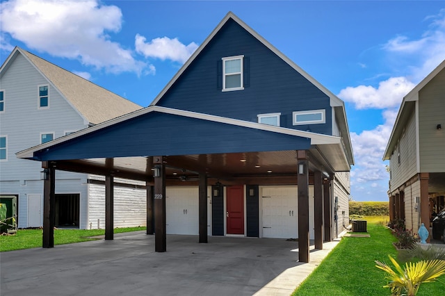 view of front of property featuring a carport, a garage, a front yard, and central air condition unit