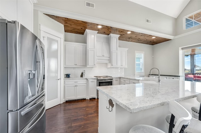 kitchen with a breakfast bar, sink, white cabinetry, tasteful backsplash, and stainless steel appliances