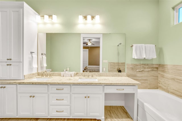 bathroom featuring vanity, a washtub, and ceiling fan