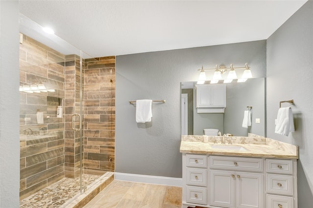 bathroom featuring vanity, toilet, and walk in shower