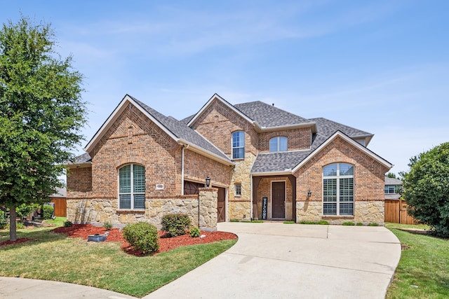 traditional home with roof with shingles, fence, concrete driveway, and brick siding