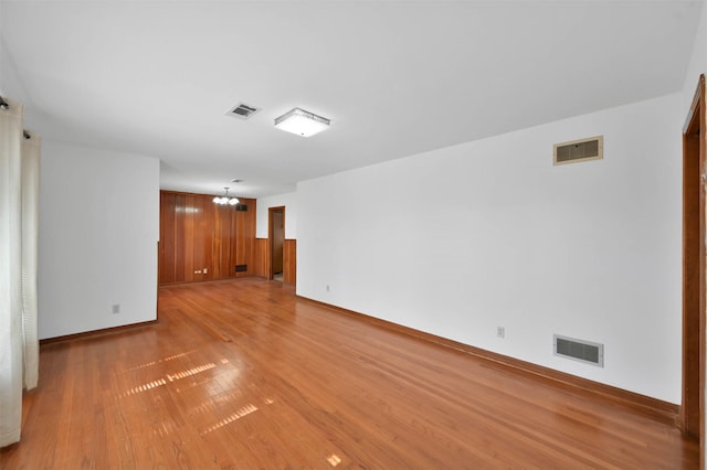 empty room with an inviting chandelier and light hardwood / wood-style floors