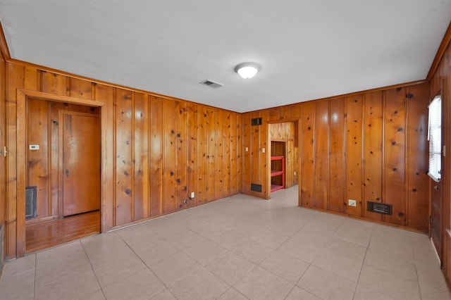 spare room featuring wooden walls