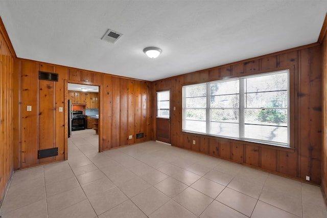 empty room featuring light tile patterned flooring and wood walls