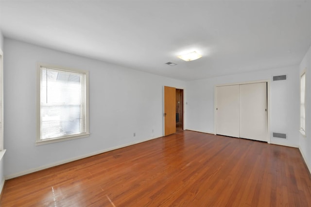 unfurnished bedroom with hardwood / wood-style floors and a closet